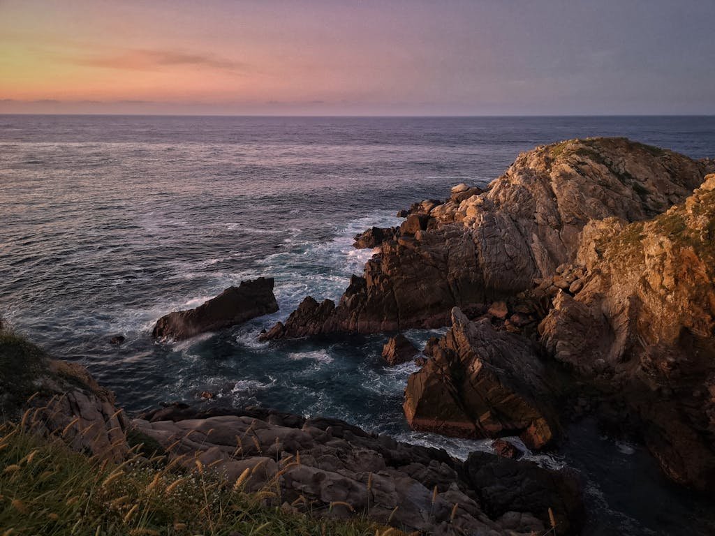 Beautiful sunset over rocky coastline in Mazunte, Mexico, capturing the serene ocean scenery.